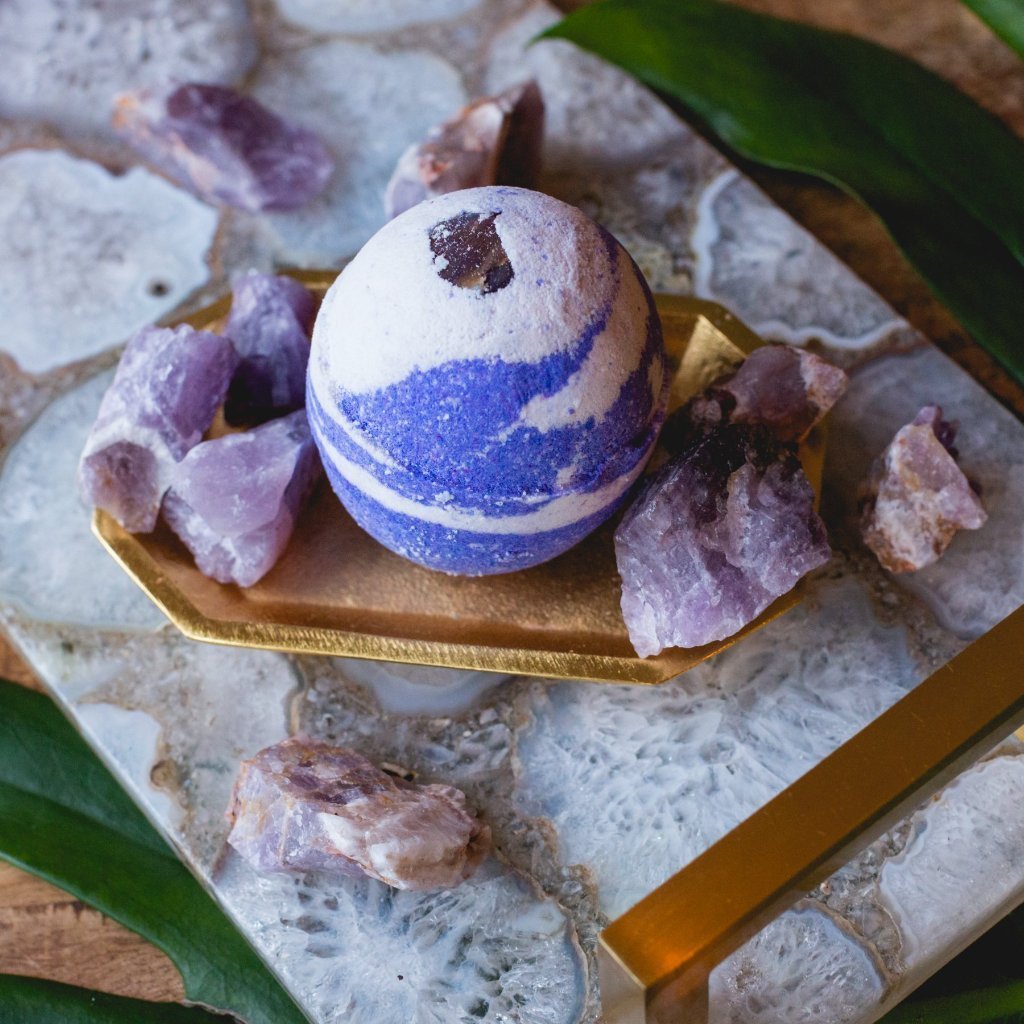 Each Bath Bomb from the Healing Stone Collection has be handcrafted with an embedded stone. Stones will vary in size and appearance. I've designed the bath bomb to mirror the stones natural beauty.  An Amethyst Stone is embedded in a purple and white bath bomb