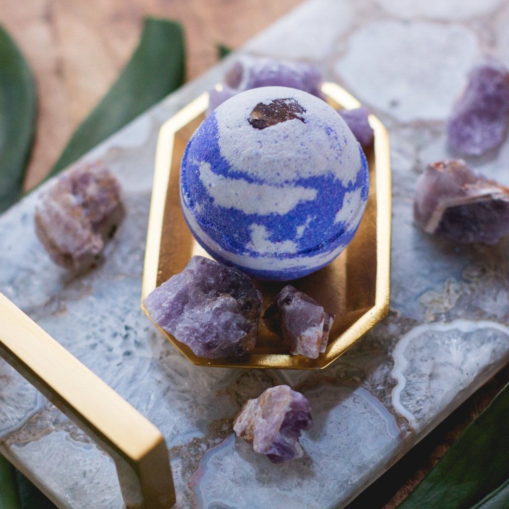 Each Bath Bomb from the Healing Stone Collection has be handcrafted with an embedded stone. Stones will vary in size and appearance. I've designed the bath bomb to mirror the stones natural beauty.  An Amethyst Stone is embedded in a purple and white bath bomb